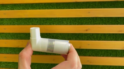 inhaler. Inhaler close-up. wooden wall. Slow motion video. Vertical video. High quality 4K footage.