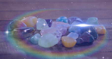 Image of stars and light spots over colourful stones, copy space