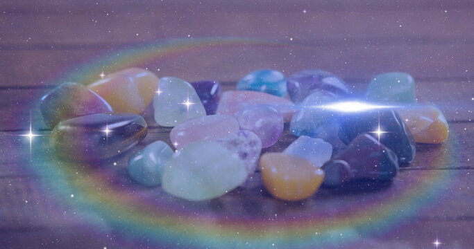 Image of stars and light spots over colourful stones, copy space