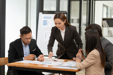 Asian business group discussing graph work at the office