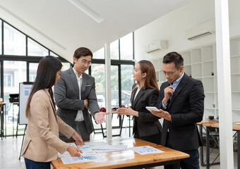 Fototapeta premium Asian business group discussing graph work at the office
