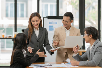 Asian business group discussing graph work at the office