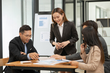 Asian business group discussing graph work at the office