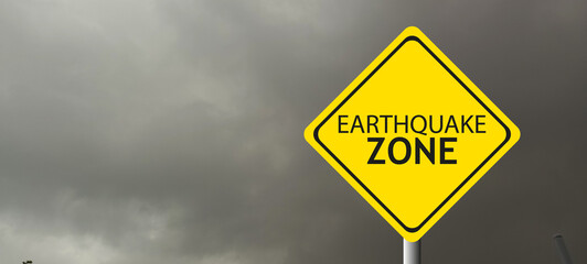 Caution Earthquake Zone Sign on Cracked Rock Background