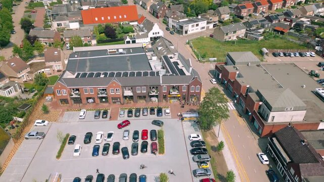 Aerial view of the parking lot and new shopping mall in Budel village, Cranendonck. Captures the modern commercial area and surrounding rural landscape. Location: Budel, Cranendonck, Brabant,
