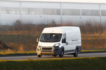 White delivery van speeding along scenic country road