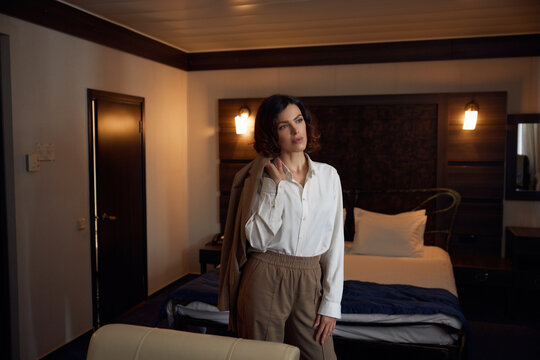 Portrait of thoughtful elegant business woman in hotel bedchamber
