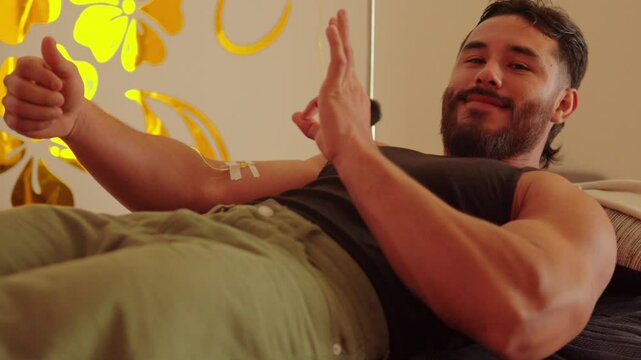 Latin mexican model male soldier muscle handsome during iv drip intravenous therapy treatment at nursery spa wellness center saying ok good enjoy smile beard
