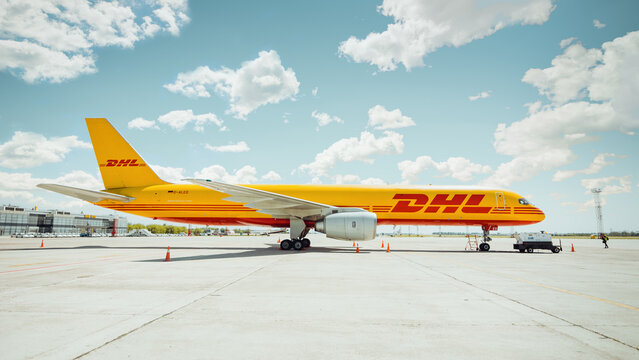 DHL cargo Boeing 757 (D-ALED) parked on apron; side view of the yellow aircraft. Boryspil International Airport, Ukraine - May 22 2015.