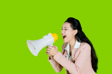 business woman screaming with a megaphone in the studio with green screen