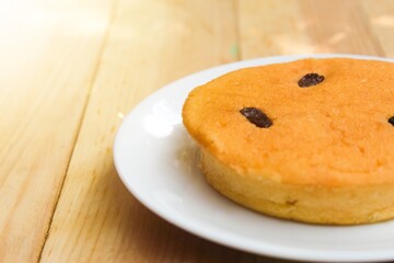 close up of a plate of sponge cake with negative space on a wooden table