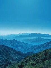 Fototapeta premium Cerulean heights of a clear, blue sky over mountains provide a stunning backdrop for the rugged landscape below.