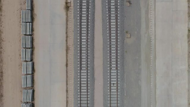 The construction of the unfinished railway line, a lot of stones on the side of the tracks.