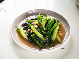 dish of stir fried Chinese kale with garlic, oyster sauce and red hot chili peppers