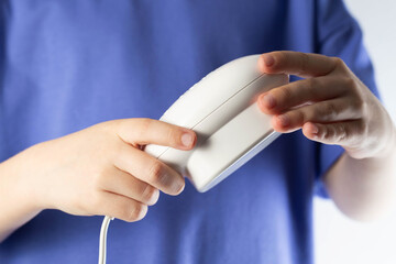 A child holds in his hands a low-frequency portable magnetic therapy device for the restoration and...