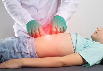 A surgeon doctor palpates the abdomen of the peri-umbilical zone during an abdominal hernia in a little girl. The concept of an extended umbilical ring, abdominal tension, umbilical hernia in children