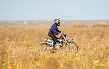 Naklejka premium A motorcyclist rides an enduro motorcycle off-road. Driving through steppe and hilly terrain. Kazakhstan, Shymkent - April 17, 2024