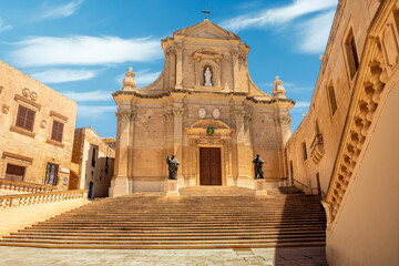The imposing facade of Roman Catholic Assumption Cathedral looms over the Citadel of Victoria, a...