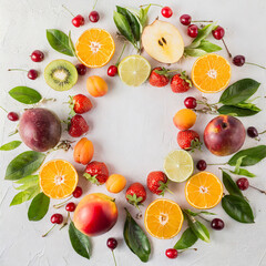 Variety of fruits and berries on white arranged in a frame with copy space, top view