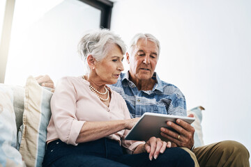 Tablet, browsing and mature couple in living room in house for online movie streaming on website. Subscription, tech savvy and people in home with networking, social media and app in retirement.