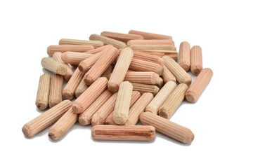 In the photo, dowels made of wood used in furniture production are lying in a heap.