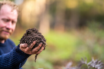 turning a compost pile in a community garden. compost full of microorganisms. sustainable regenerative agriculture