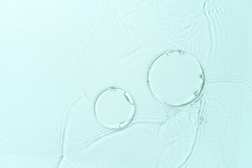 Cosmetic product presentation mockup scene featuring two empty round glass podiums on turquoise water surface with splashes.