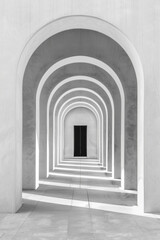 A plain door framed by a series of minimalist arches, each arch slightly larger than the one before, creating a sense of depth and perspective. The background remains solid and neutral