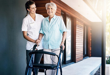 Senior, woman and nurse outside with walker, movement and wellness care with healthcare employee in nursing home. Rehabilitation, walking and support with caretaker, physical therapy and happy people