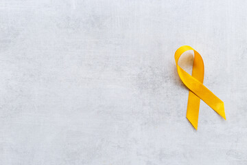 Yellow ribbon symbol of bone cancer and suicide problems awareness concept