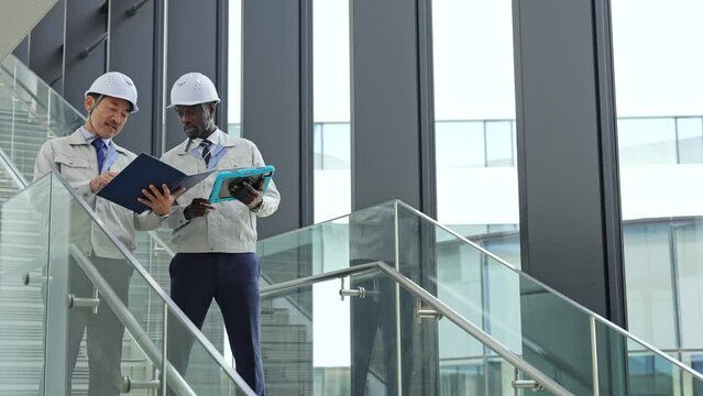 Group of multinational engineers inspecting a building