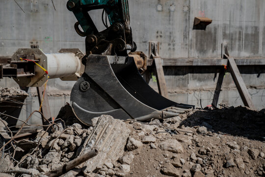 Black dark construction bucket on construction project rubble for excavation works.. close up of excavator bucket