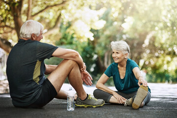 Senior man, woman and sitting in street for workout, discussion for retirement with smile. Couple, exercise and together with pause for happiness on road, stretching with chat in neighborhood