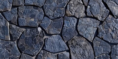 Obraz premium Close-up of a textured stone surface with various shapes and shades of blue and gray stones arranged in a mosaic pattern.