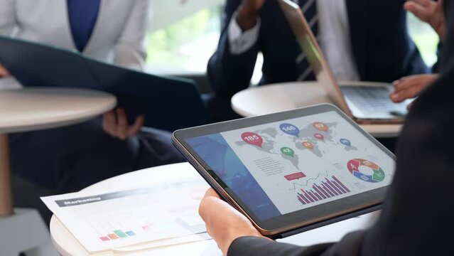 A group of business people having a meeting while looking at a tablet