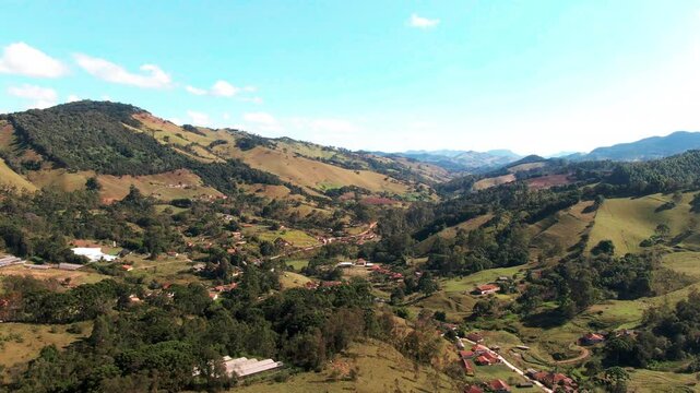 A scenic aerial view showcasing the rolling hills and lush greenery of the countryside in Delfim Moreira, Minas Gerais, Brazil.