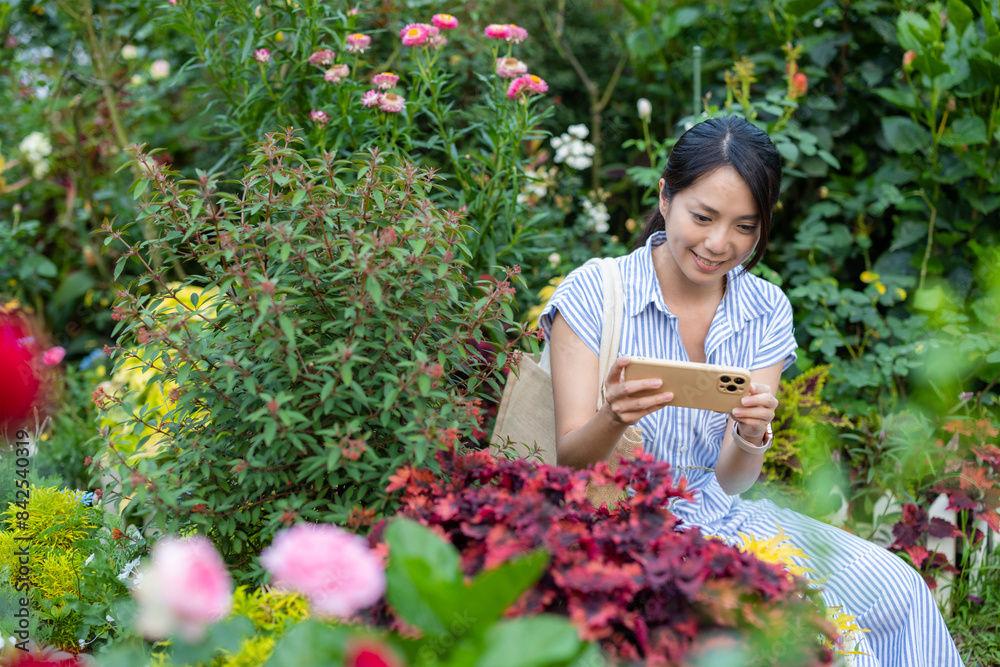 Canvas Prints Woman take photo on mobile phone in the flower garden