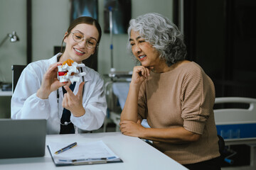 Female doctor consulting senior old patient filling form at consultation, talking to senior old patient filling signing medical paper at appointment visit in clinic.