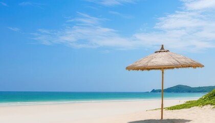 a straw umbrella on a sandy beach near the ocean