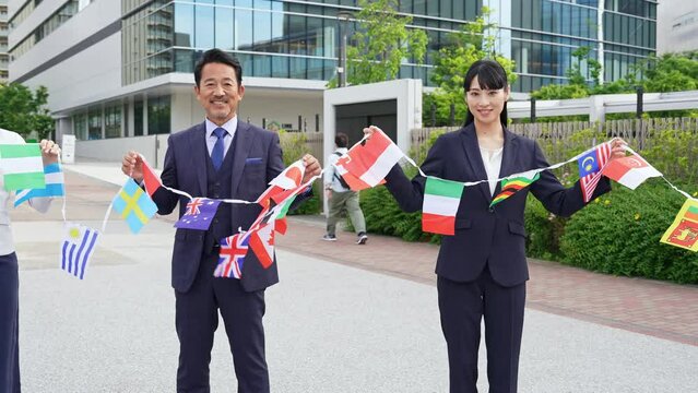 万国旗を持つ多国籍ビジネスパーソンのグループ