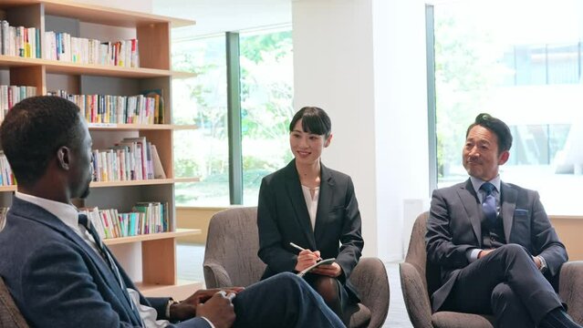 ラウンジで会話する多国籍ビジネスパーソンのグループ