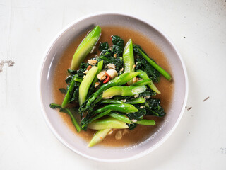 top view dish of stir fried Chinese kale with garlic and red hot chili peppers