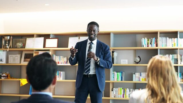 Black businessman giving a speech in front of an audience