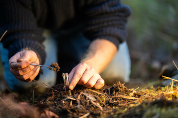 soil falling around a test tube collecting a soil collecting a soil sample in a paddock on a farm...