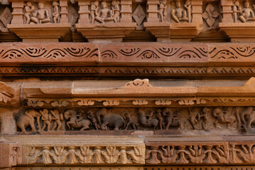 Sculpture and intricate designs on the wall of Chitragupta Temple in the Khajuraho temple complex, India