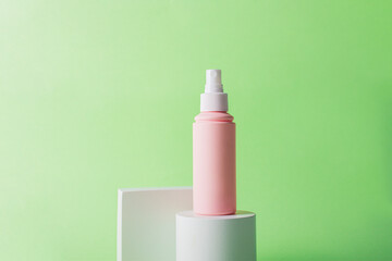Plastic white tube for cream or lotion. Skin care or sunscreen cosmetic with stylish props on green background.