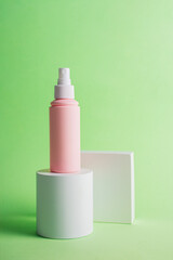 Plastic white tube for cream or lotion. Skin care or sunscreen cosmetic with stylish props on green background.