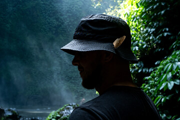 A man experiences a moment of connection with nature, a butterfly landing softly on his hat, by a...