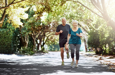 Running, park and old couple with sunshine, training and bonding together with challenge. Outdoor, senior man and mature woman with fitness, retirement and hobby with exercise, healthy and wellness