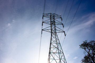 high voltage pylon against blue sky,  Sute tower electric high voltage blue sky tower sutet indonesia, Transmission tower or power line on a sunny day. These are scattered throughout in indonesia